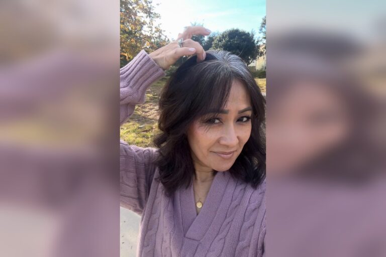Close-up of my natural gray hair grow-out showing a defined skunk stripe down my part—capturing the beginning of my gray hair transition.